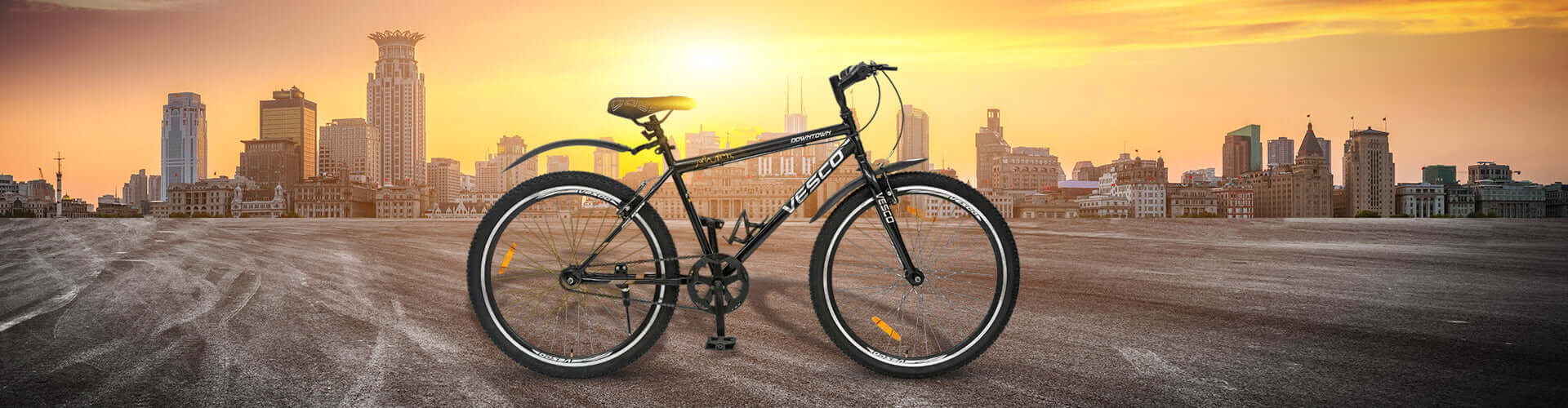Bicycle on a road with a city skyline and sunset in the background